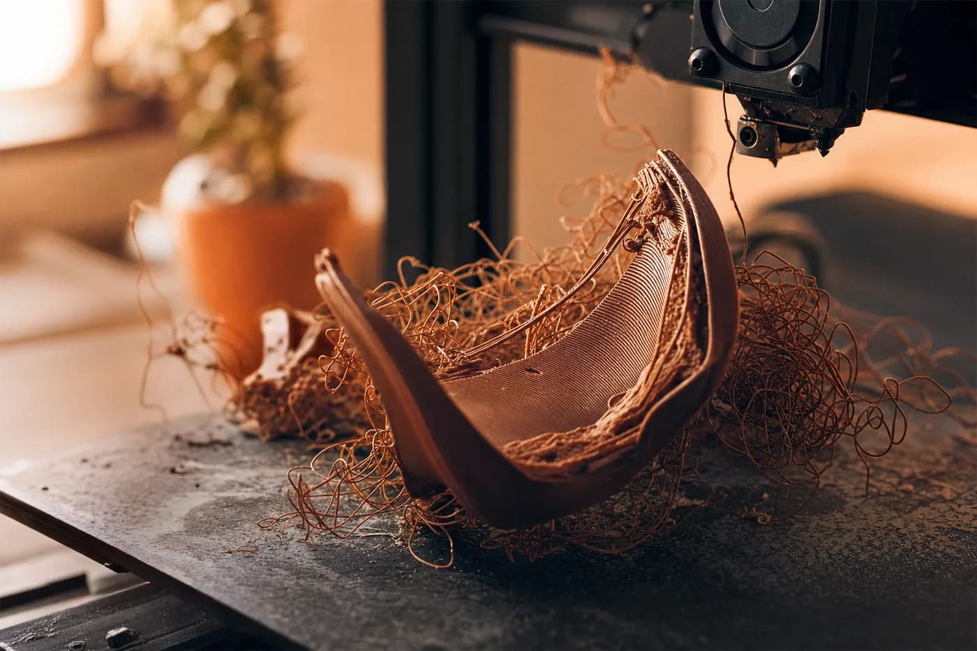 Uma impressão 3D falhada, empenada e solta da mesa